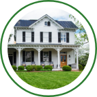 A large white country house with a covered front porch. 